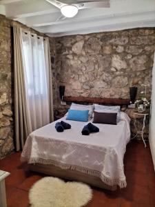 una camera con un letto e un muro in pietra di Casa Nani a Benaocaz