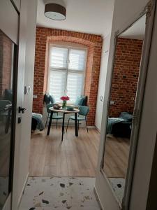 una stanza con tavolo, sedie e un muro di mattoni di przytulnie w Łodzi a Łódź