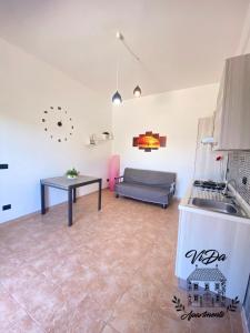 a kitchen and living room with a couch and a table at ViDa Apartments casa vacanze in Frigole