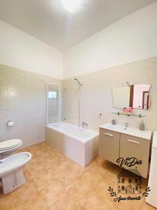 a bathroom with a tub and a toilet and a sink at ViDa Apartments casa vacanze in Frigole