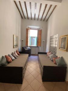 Zimmer mit 3 Betten und einem Sofa in der Unterkunft Artemisia in Pisa