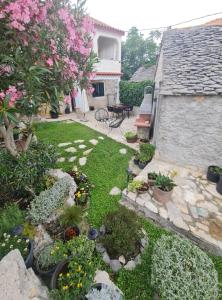 un cortile con giardino fiorito e piante di Holiday Home Little Heaven a Slatine