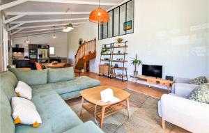 ein Wohnzimmer mit blauen Sofas und einem Tisch in der Unterkunft Pet Friendly Home In Colonzelle With Private Swimming Pool, Can Be Inside Or Outside in Colonzelle