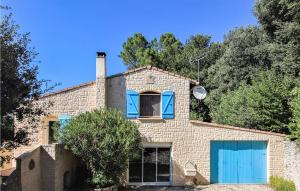 a brick house with blue doors and trees at 3 Bedroom Lovely Home In Colonzelle in Colonzelle