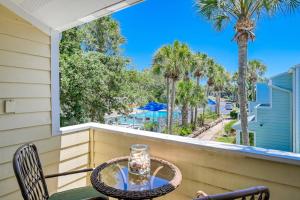 a table and chairs on a balcony with palm trees at Sea Turtle Shores in St. Augustine