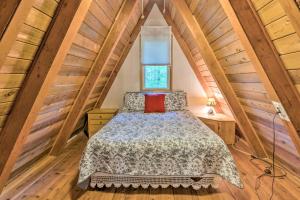 Hot Tub, Sauna, Fireplace, Dock! Lake Honor Cabin في Honor: غرفة نوم بها سرير في العلية