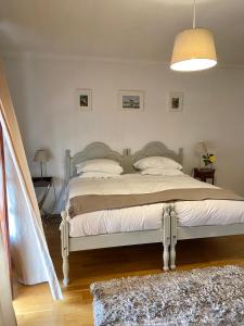 a bedroom with a large bed with a white bedspread at House in the Town Centre in Caminha