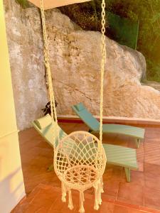 a rattan swing in a room with a chair at Es Cucó in Cala Galdana