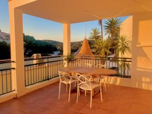 a table and chairs on a balcony with a view at Es Cucó in Cala Galdana