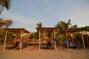 a group of chairs and umbrellas on a beach at Mamaqocha in Canoas de Punta Sal