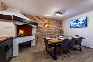 a dining room with a fireplace and a table and chairs at Villa Matea - heated pool, peace, view in Pridraga