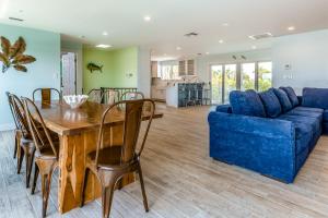 a living room with a wooden table and a blue couch at Shady Deck in Key Colony Beach