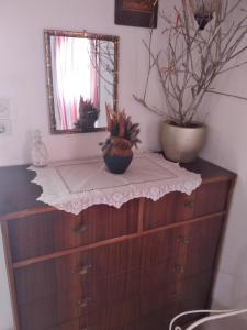 a dresser with a mirror and two potted plants on it at Amaryllis sweet home in Pyrgos