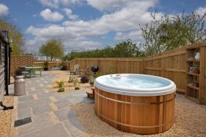 a hot tub in a backyard with a fence at Windmill Flower Barn in Langport