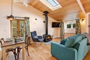 a living room with a blue couch and a wood stove at Windmill Flower Barn in Langport