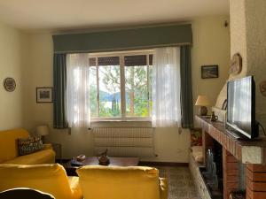 een woonkamer met een bank en een raam bij Casetta Lake and Sun in Labro
