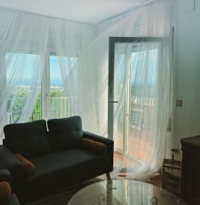 een woonkamer met een bank en een groot raam bij Villa Mas Blau Mar in Lloret de Mar