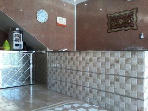 a restaurant with a counter with a clock on the wall at Zaer Al Fakhama Hotel Apartments in Tabuk