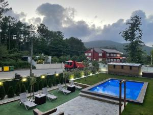 a backyard with a swimming pool and a red truck in the background at Apartamentos Toffe in Outes
