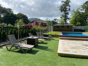 a yard with lounge chairs and a swimming pool at Apartamentos Toffe in Outes