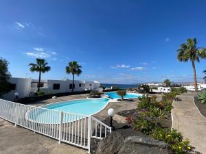 a view of a swimming pool with palm trees at Miramar in Puerto del Carmen