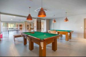 duas mesas de bilhar numa sala grande com bolas de pingue-pongue em Golden Gramado Resort em Gramado