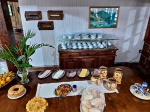 a table with plates of food and a buffet of dishes at Pousada Cascata in Casimiro de Abreu
