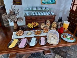 stół z wieloma talerzami jedzenia w obiekcie Pousada Cascata w mieście Casimiro de Abreu