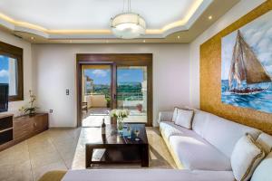 a living room with a white couch and a tv at Villa Alexandra in Kolymvari