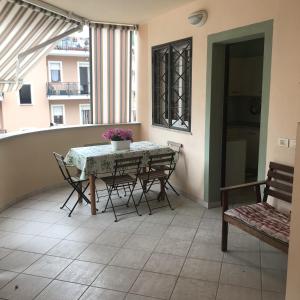 d'un balcon avec une table, des chaises et une fenêtre. dans l'établissement Estate Famiglia Andora, à Marina dʼAndora
