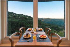 a table with plates of food on it with a large window at Golden Gramado Resort in Gramado