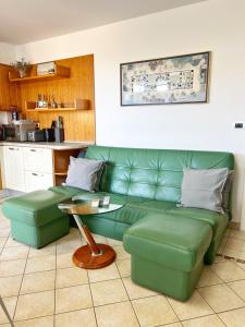 uma sala de estar com um sofá verde e uma mesa em Villa Moare em Koper