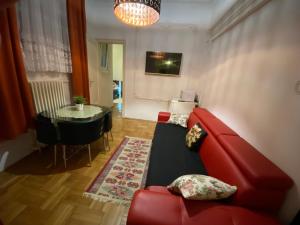 a living room with a red couch and a table at Monolit Budapest Center Guesthouse in Budapest