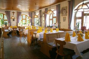 um restaurante com mesas com guardanapos amarelos em Pension-Metzgerei Hofer em Inning am Holz