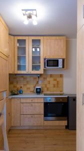 cocina con armarios de madera y horno con fogones en Aranypart Apartman, en Siófok