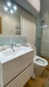 a bathroom with a white sink and a toilet at Aranypart Apartman in Siófok