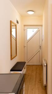 a bathroom with a door with a mirror and a counter at Aranypart Apartman in Siófok