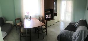 a living room with a bed and a table with a laptop at Estate Famiglia Andora in Marina dʼAndora