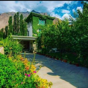 a house with a lot of plants in front of it at Al Amin Guest House - Home away from Home in Skardu