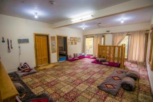 a room with a crib and a large rug at Al Amin Guest House - Home away from Home in Skardu