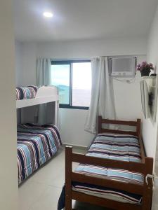 ein Schlafzimmer mit zwei Etagenbetten und einem Fenster in der Unterkunft APARTAMENTO PORTO REAL RESORT VISTA ESPETACULAR 2 in Mangaratiba + 55 Fotos