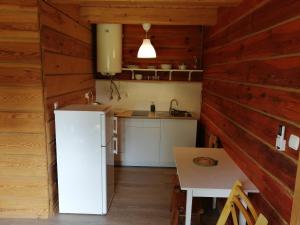 a kitchen with a white refrigerator and a table at Radawa Family Space in Radawa
