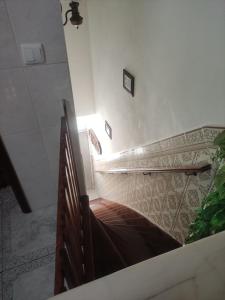 a staircase in a building with a wooden railing at Casa da Cristina in Nazaré