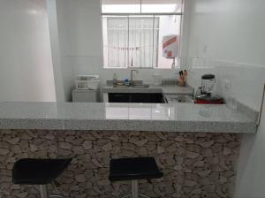 uma cozinha com um balcão com dois bancos de bar em Apartamento Amoblado en Tacna em Tacna