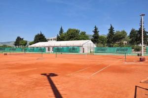 una pista de tenis con dos redes de tenis en Apartments Zizic, en Kaštela