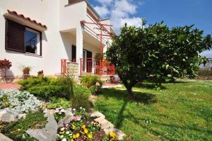 a house with a garden with flowers in the yard at Apartments Zizic in Kaštela