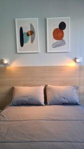 1 dormitorio con 1 cama con 2 cuadros en la pared en MARAVILHOSO ESTÚDIO- PRAIA DE BOTAFOGO en Río de Janeiro