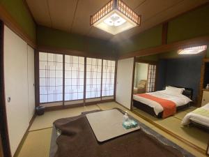 una camera da letto con un letto e un grande specchio di 鉄道と山の見える家 a Yufu Altre 26 foto