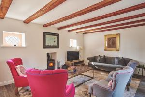 a living room with a couch and chairs and a table at Redwood Cottage in Nantwich