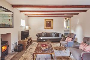 a living room with two couches and a fireplace at Redwood Cottage in Nantwich +9 photos